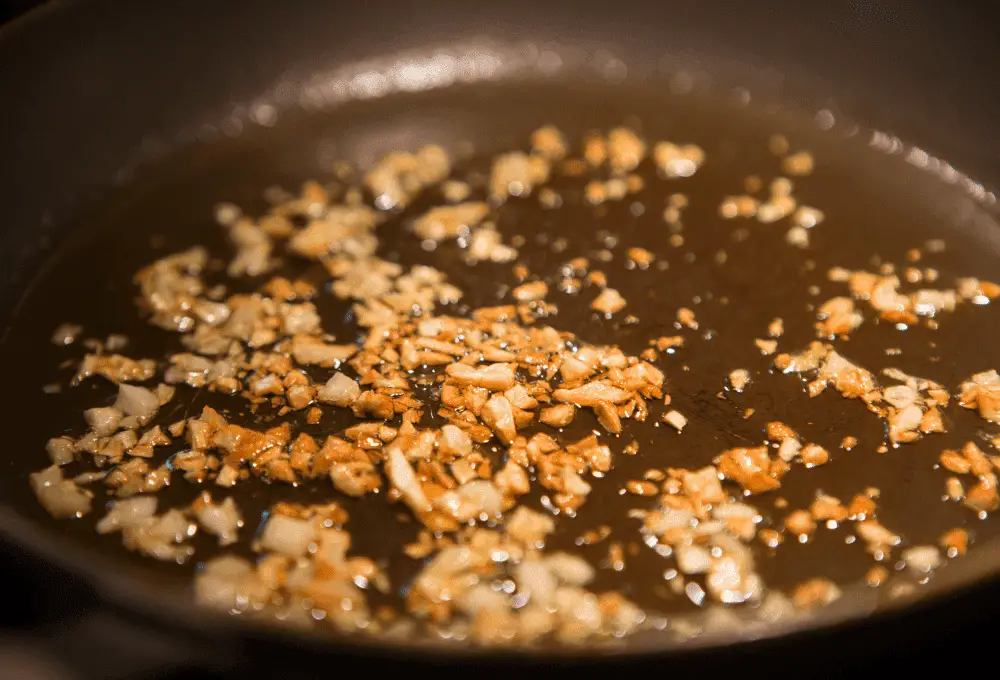 Garlic sautéing with olive oil and butter in a skillet.