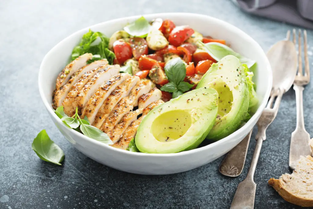 Image of Rustic Avocado Salad and Caprese Chicken Fusion served on a white plate.