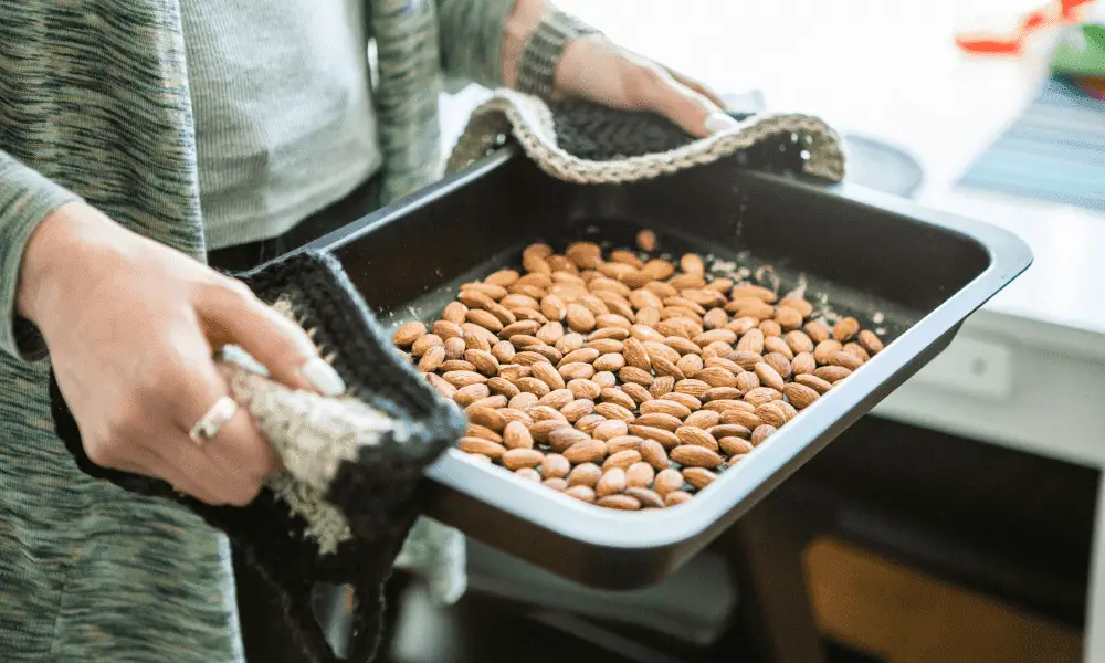 Golden-brown roasted almonds spread out on a baking tray, emitting a warm, nutty aroma."