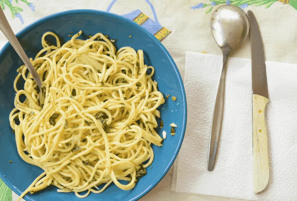 Plated Lemon Garlic Pasta garnished with fresh parsley and a sprinkle of Parmesan, served on a white plate with a fork.