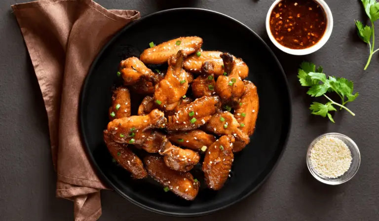 Serving of crispy chicken wings coated in a shiny honey soy glaze, ready to be enjoyed.