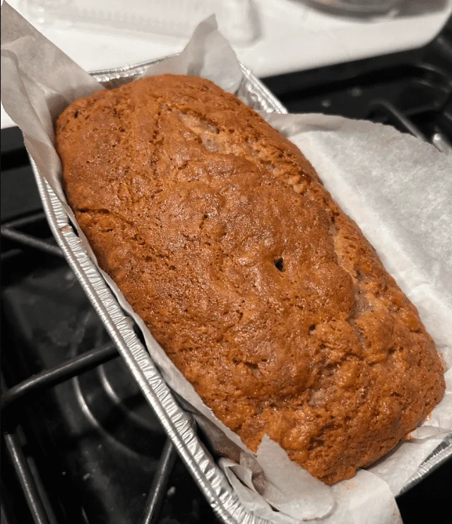 Warm and aromatic vegan banana bread, freshly baked with a glistening top.