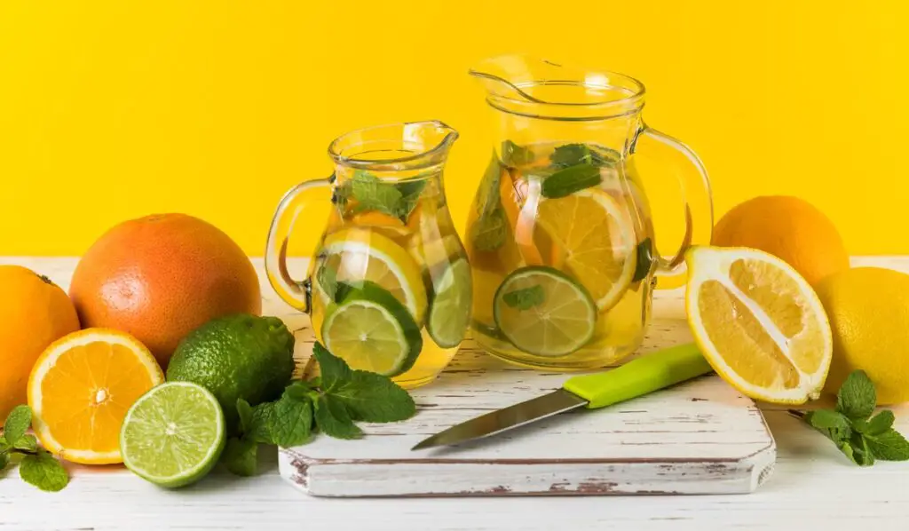 Close-up shot of a crystal-clear glass filled with refreshing infused water, glistening with vibrant fruit slices and a hint of mint.