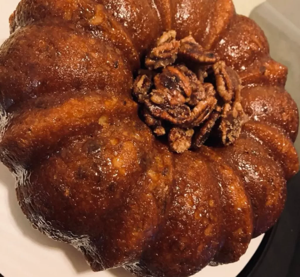 Buttery Southern Butter Pecan Pound Cake drizzled with sweet praline glaze on a serving plate.