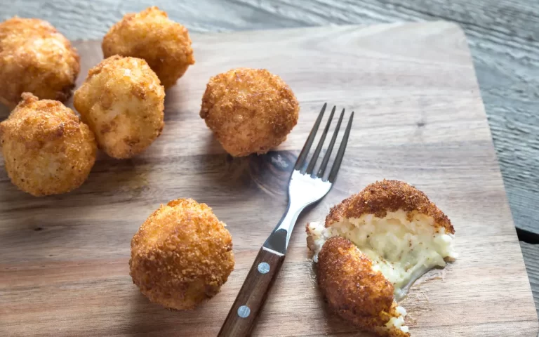 Golden fried Mozzarella Balls on a plate with marinara dipping sauce.