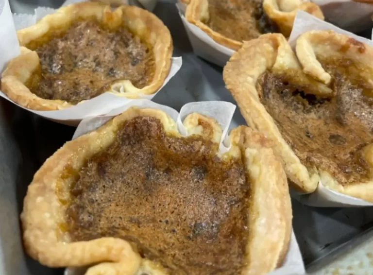 A plate of freshly baked butter tarts with a golden crust.