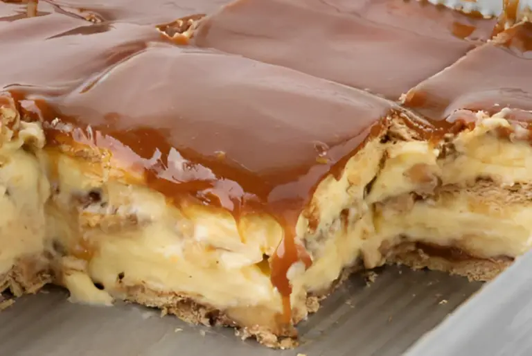 Layered Caramel Apple Eclair Cake with creamy vanilla pudding, spiced cinnamon apples, and a glossy caramel topping.