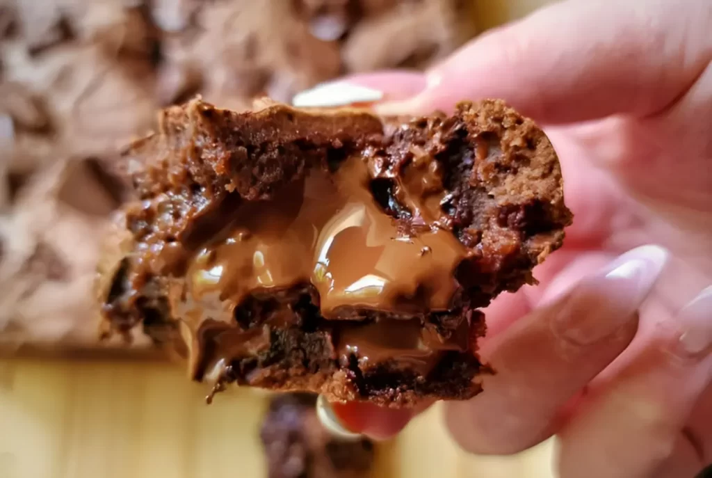 Delicious and gooey Caramel Brownies stacked on a plate, drizzled with caramel sauce.