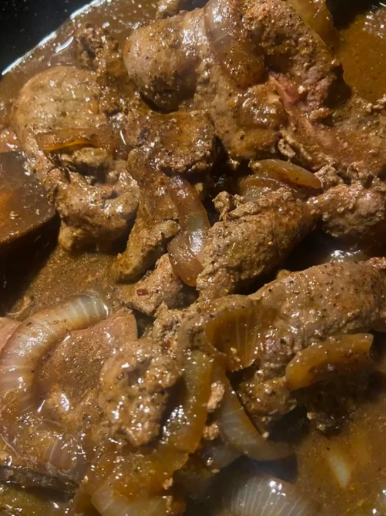 Sliced beef liver served with caramelized onions and rich brown gravy