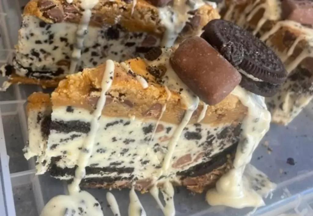 A slice of the Ultimate Oreo Cheesecake with a creamy filling, Oreo chunks, and a chocolate cake base.