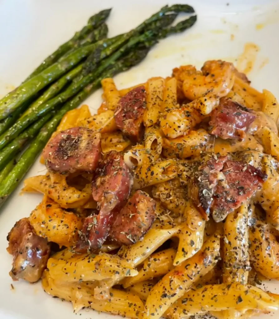 A plate of Creamy Smoked Sausage Pasta garnished with Parmesan and parsley.