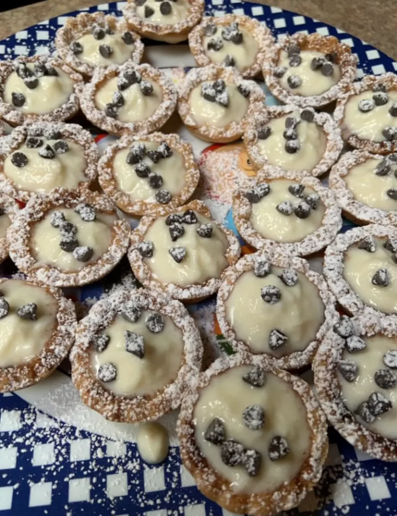 Bite-sized Mini Cannoli Cups with creamy ricotta and chocolate chip filling in golden puff pastry shells.