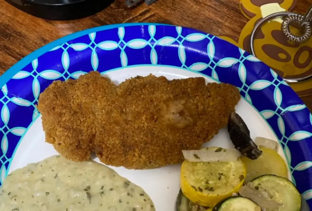 Crispy Parmesan Oven-Fried Chicken on a plate with golden breadcrumb coating.