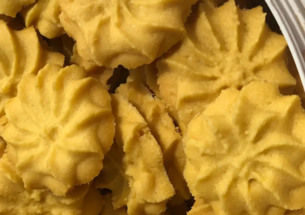 Golden-brown butter cookies on a cooling rack, showcasing their delicate crumbly texture and rich buttery appearance.