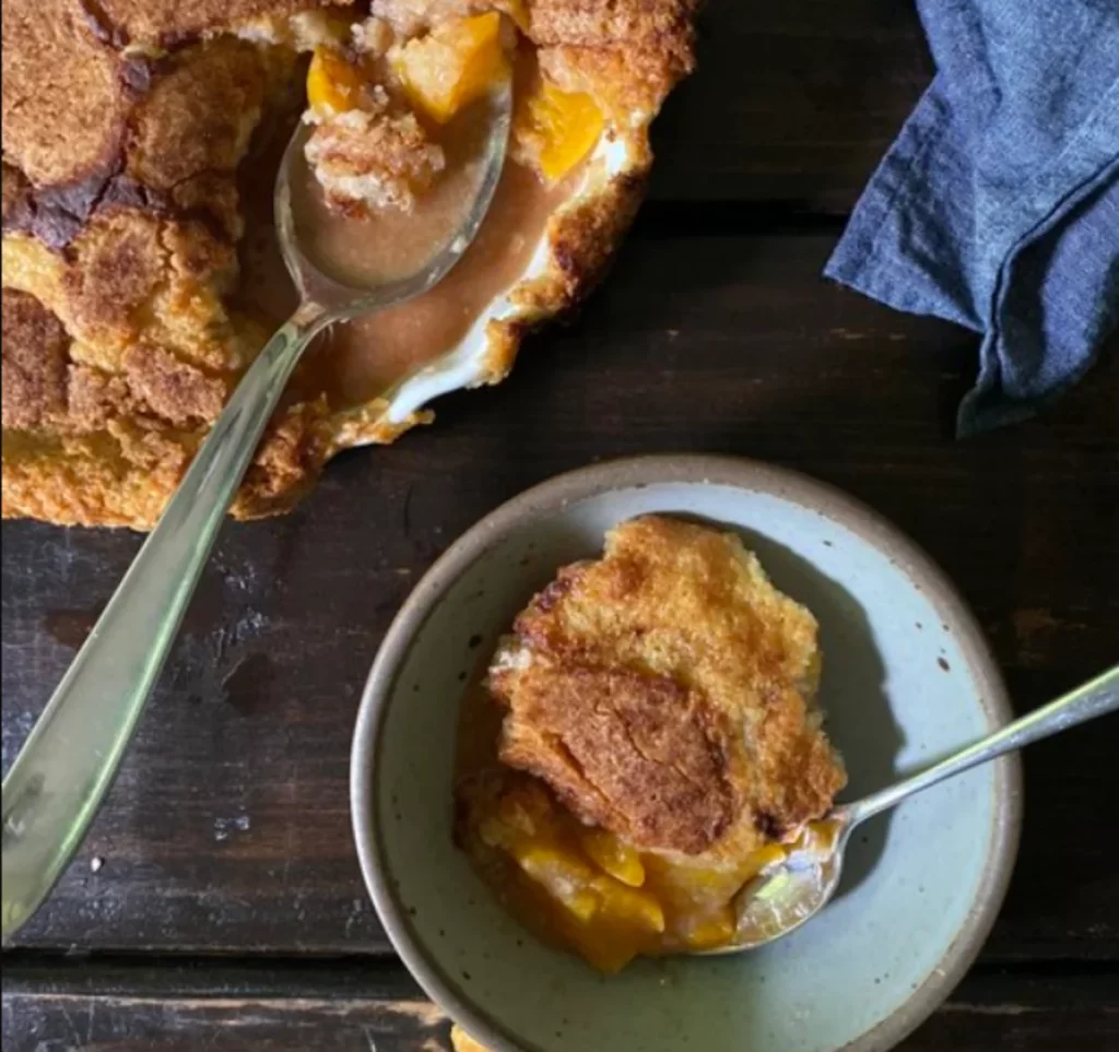 A freshly baked Snickerdoodle Cobbler with a golden cinnamon-sugar crust and soft, warm center.