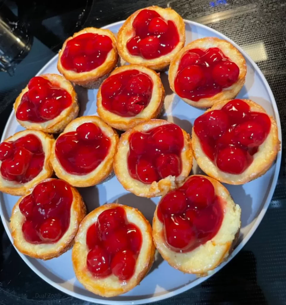 A plate of Mini Cherry Cheesecakes with a graham cracker crust, creamy filling, and cherry topping.