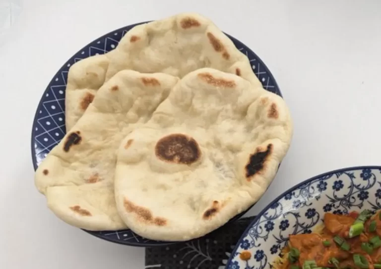 Fresh homemade naan bread on a kitchen counter, ready to be served.